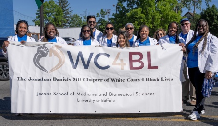 Group of medical students and faculty members wearing white coats holding the banner that reads WC4BL White coats for Black Lives. 