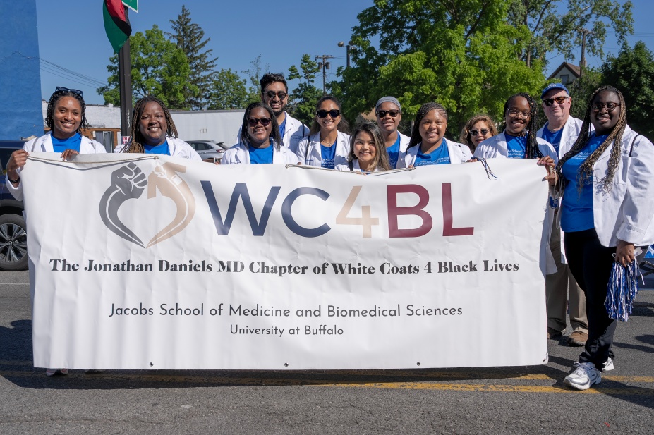 Group of medical students and faculty members wearing white coats holding the banner that reads WC4BL White coats for Black Lives. 