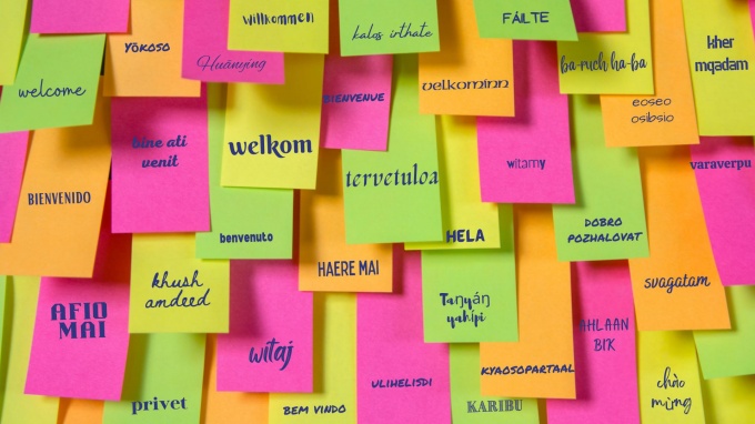 post it note wall with the word welcome in different languages. 