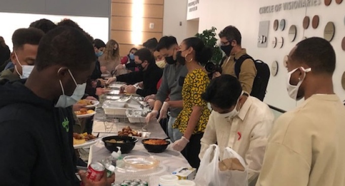 Group of young people getting served food. 