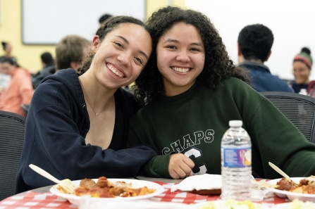 Students eating pasta at a social event. 