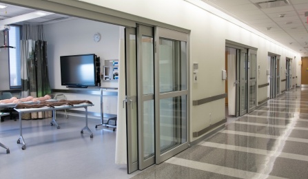 Hallway in the Ralph T. Behling Simulation Center with a view of a training room. 