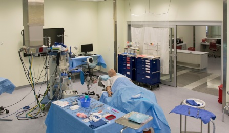 A view of the operating room with a simulator on the table covered with surgical drapes. 
