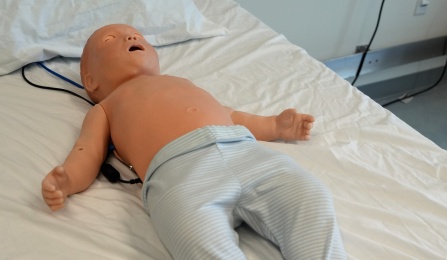 Laerdal's SimBaby in a hospital bed.