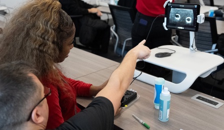 A medical professional explains an ultrasound image to a student. 
