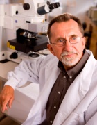 Michal Stachowiak in white coat in lab. 