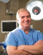 Dr. Schwaitzberg in scrubs in OR, smiling. 